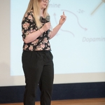 Woman presenting, a finger gesturing as she speaks